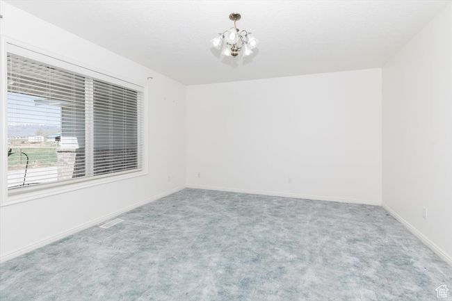Spare room featuring carpet floors and a chandelier | Image 20
