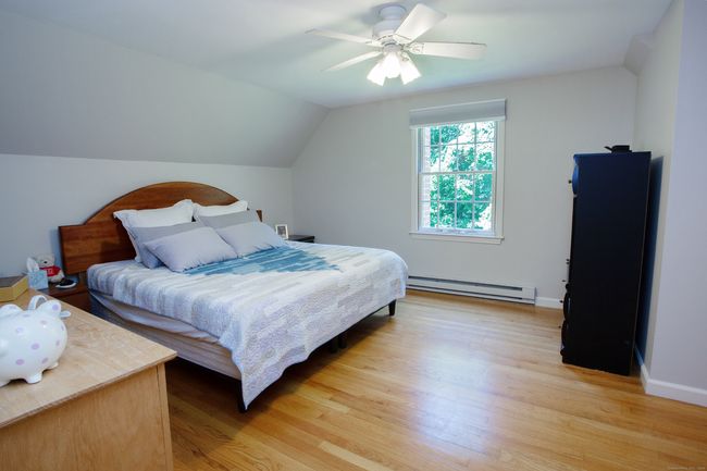 Beautiful expanded primary bedroom with hardwood floors, with ample closets including a walk-in and a set-up for laundry if you want to move it out of the basement. | Image 23