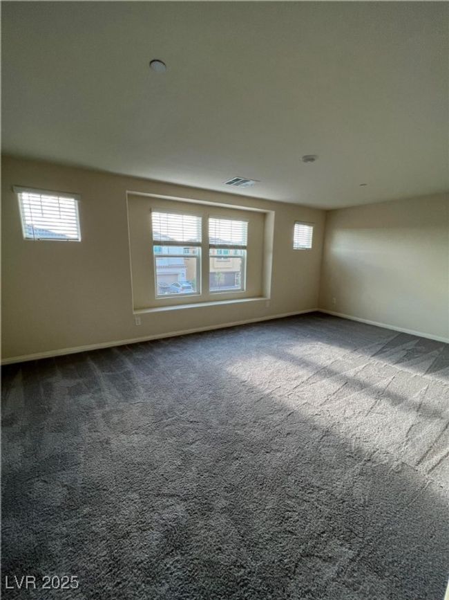 Empty room featuring plenty of natural light, dark carpet, and baseboards | Image 18