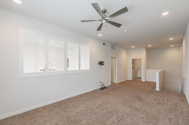 The expansive upstairs loft offers endless flexibility—ideal as a second living room, home office, media zone, or even a private retreat. Large windows with plantation shutters keep it bright yet private. | Image 8