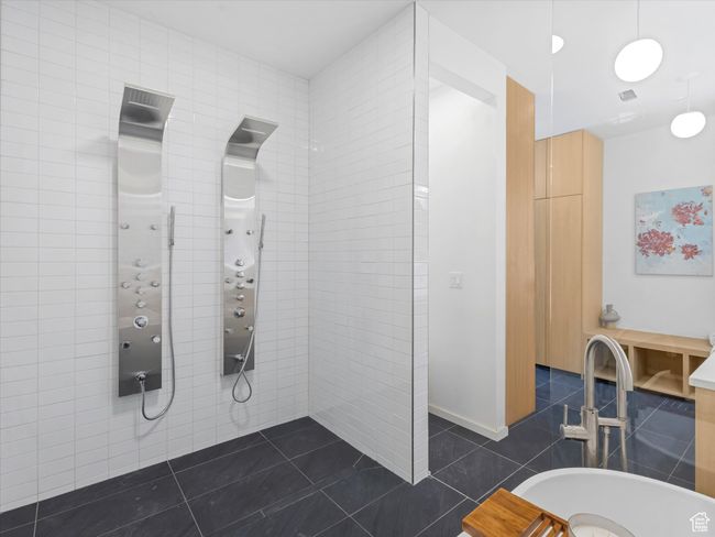 Bathroom featuring tile patterned floors, tile walls, and a tile shower | Image 23