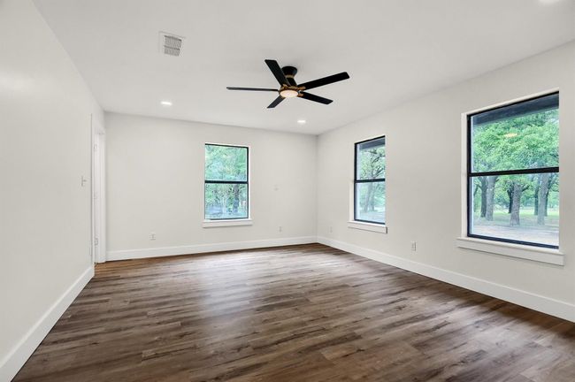 Spare room with healthy amount of natural light, dark wood-style floors, baseboards, and recessed lighting | Image 12