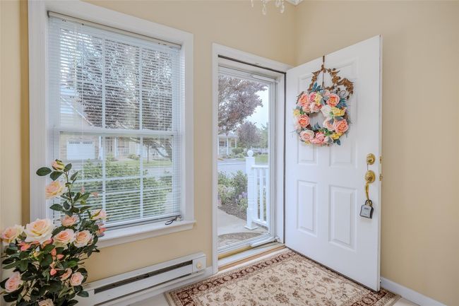 Entryway with a baseboard radiator and a chandelier | Image 4