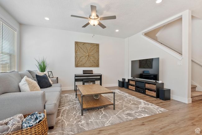 Living room with stairs, ceiling fan, wood finished floors, and recessed lighting | Image 7