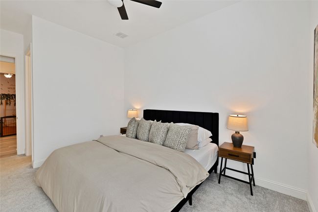 Bedroom with light colored carpet, ceiling fan, and baseboards | Image 22