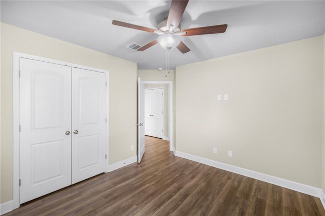 Unfurnished bedroom featuring baseboards, dark wood-type flooring, a closet, and ceiling fan | Image 23