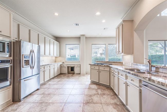 Another fire of this dream kitchen with so much cabinetry. Steel appliances, double sink and two breakfast bars open to living space. | Image 29