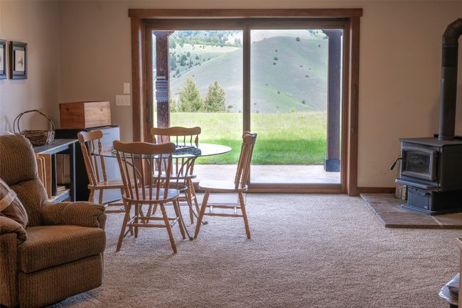 Carpeted dining area with a wood stove | Image 51