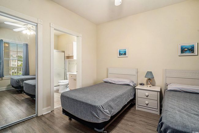 Bedroom with dark wood finished floors, ensuite bath, and baseboards | Image 12