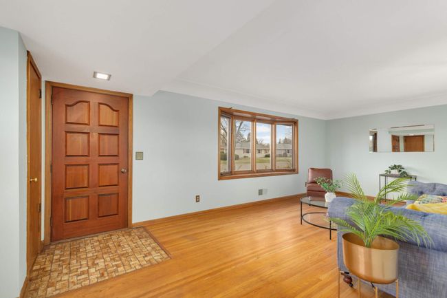 Boasting hardwood floors, the living room is generous and is drenched in light. | Image 5