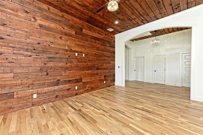 Living Room with wooden ceiling, arched walkways, wood finished floors, and wood walls | Image 9