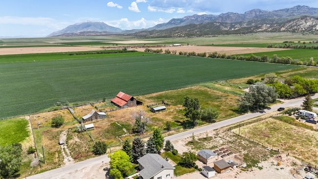 Aerial view of sparsely populated area with large plots for crops and a mountainous background | Image 8