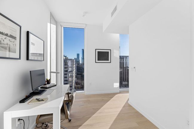 Home office featuring baseboards, expansive windows, visible vents, and light wood-type flooring | Image 17