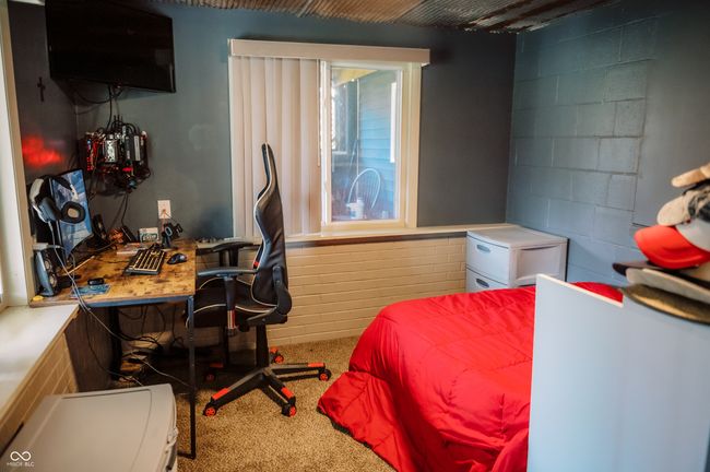 carpeted bedroom featuring concrete block wall | Image 12
