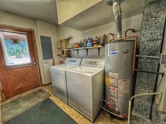 Front entry with washer/dryer, utility sink, freezer space, pantry storage, hot water heater, & furnace | Image 12