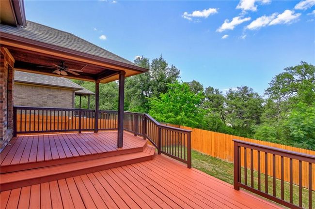 Wooden deck with a fenced backyard and ceiling fan | Image 30