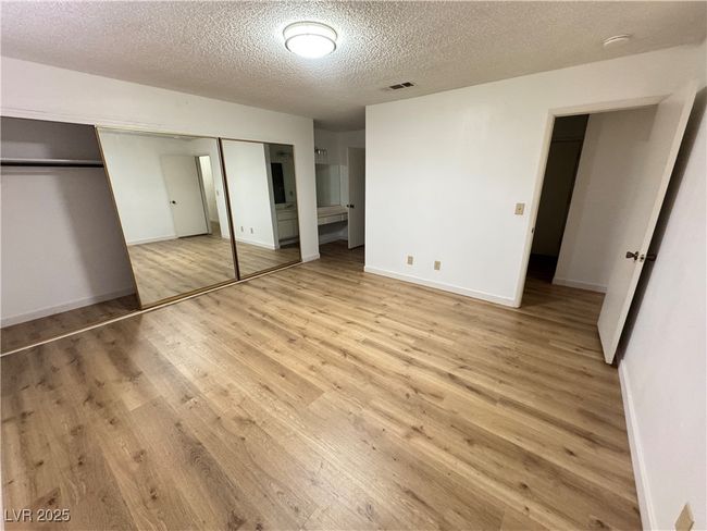 Unfurnished bedroom featuring a textured ceiling, light wood-style flooring, and a closet | Image 28