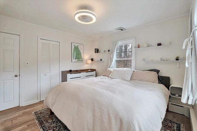Bedroom featuring a closet, visible vents, crown molding, and light wood finished floors | Image 13