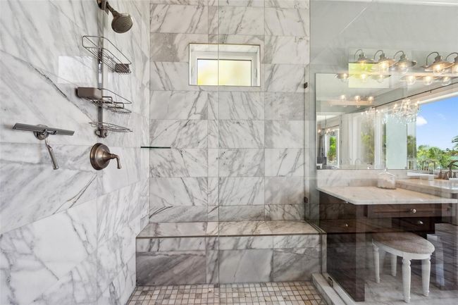Oversized walk-in master shower with bench seat and real marble tile. | Image 52