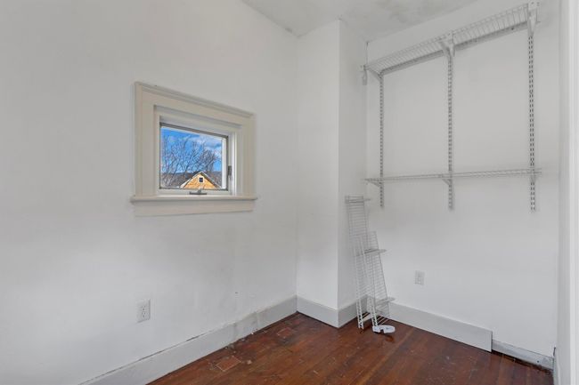 Laundry room featuring dark wood finished floors and baseboards | Image 35