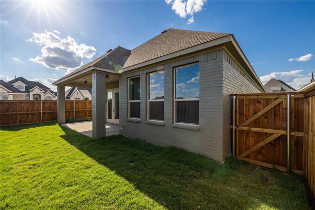 Rear view of house with a patio, brick siding, a gate, and roof with shingles | Image 31