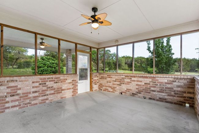 Unfurnished sunroom with plenty of natural light and ceiling fan | Image 34