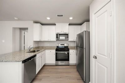 Stainless Steel appliances with white cabinets. | Image 2