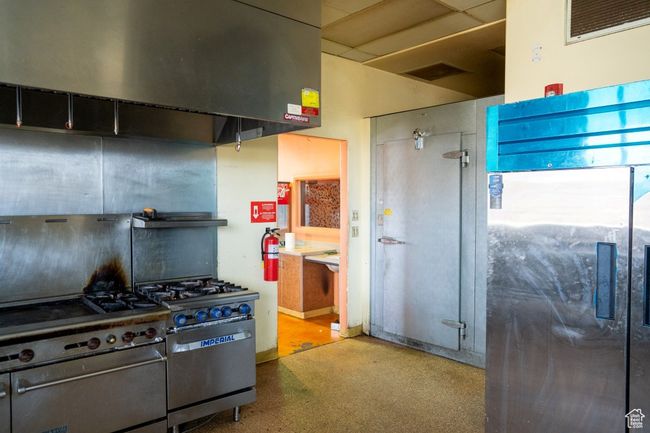 Kitchen with high end range, visible vents, and ventilation hood | Image 32