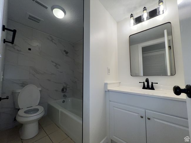 Full bathroom featuring toilet, vanity, shower combination, and tile patterned flooring | Image 8