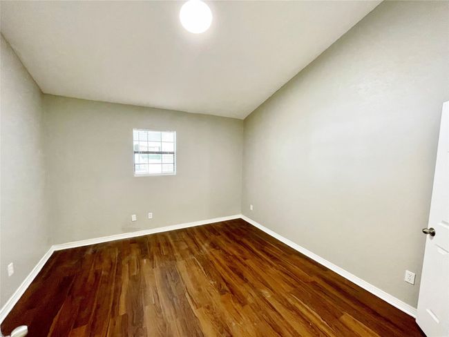 Spare room featuring baseboards and dark wood-type flooring | Image 21