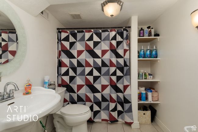 Bathroom with tile patterned floors, toilet, and a shower with curtain | Image 47