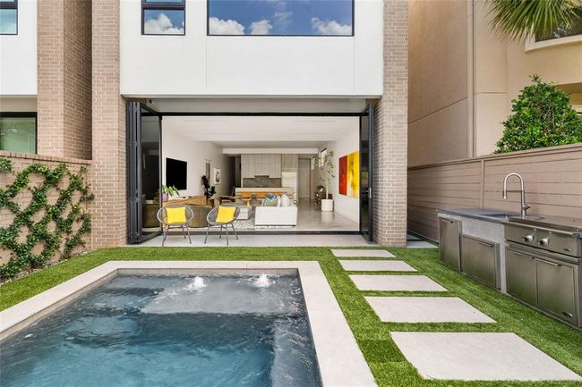 Walls of Ram sliding doors create a seamless indoor-outdoor flow, connecting the open-concept living space to a sleek retreat. Enjoy the heated plunge pool, vine-covered privacy wall, and outdoor kitchen with DCS appliances—all framed by clean lines and modern finishes that elevate everyday living and entertaining. | Image 6