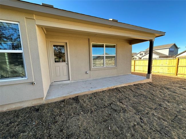 View of exterior entry featuring fence, stucco siding, and a patio area | Image 25