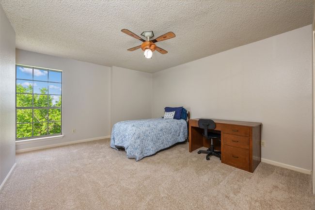 Carpeted bedroom featuring ceiling fan, baseboards, and a textured ceiling | Image 21