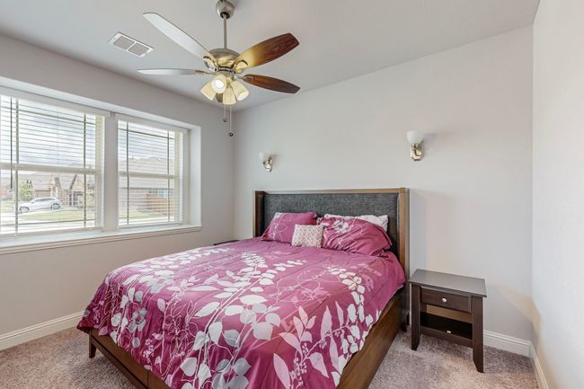 Bedroom featuring baseboards, visible vents, carpet, and a ceiling fan | Image 25