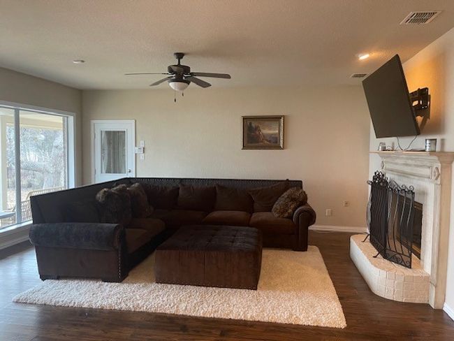 Living area with ceiling fan, baseboards, visible vents, and dark wood-style flooring | Image 10