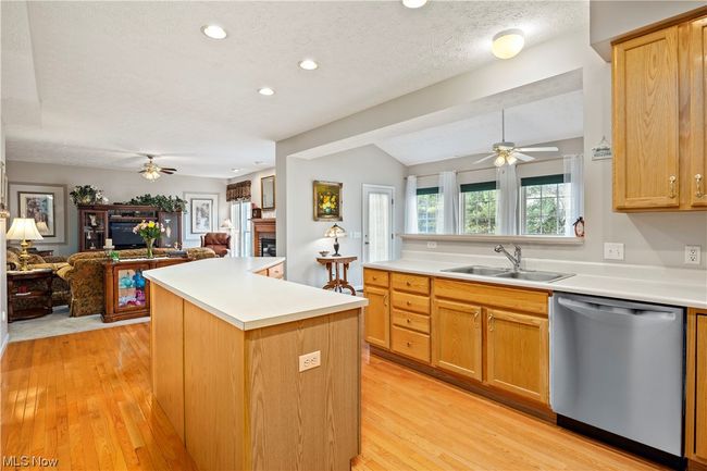 Kitchen featuring sink, dishwasher, a center island, light hardwood / wood-style floors, and lofted ceiling | Image 10