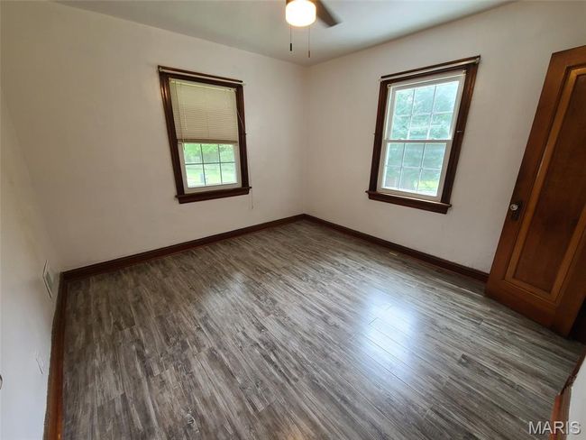 Spare room featuring healthy amount of natural light, wood finished floors, and ceiling fan | Image 11