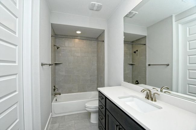 Bathroom featuring toilet, vanity, and bathtub / shower combination | Image 23