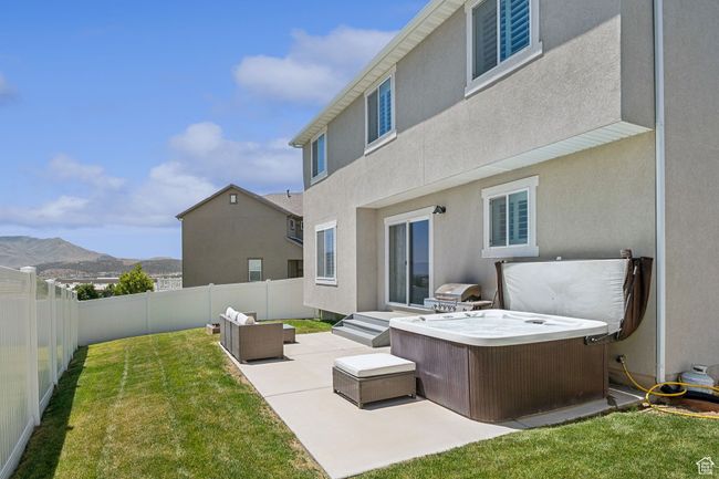 Back of house with a fenced backyard, a patio area, a mountain view, a hot tub, and outdoor lounge area | Image 30