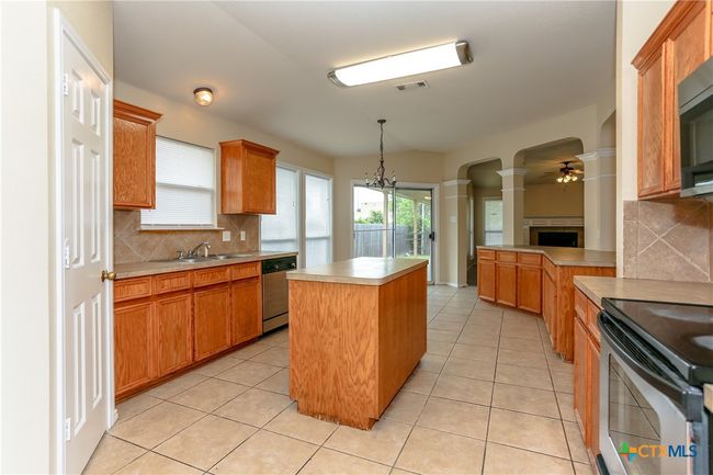 Kitchen featuring lots of counter space. Sliding glass door leads outside to the backyard. | Image 15