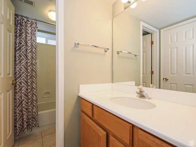 Full bath featuring visible vents, tile patterned floors, vanity, and shower / bathtub combination with curtain | Image 17