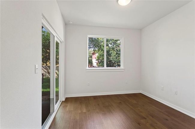 Empty room with plenty of natural light, dark wood-style floors, and a smoke detector | Image 14