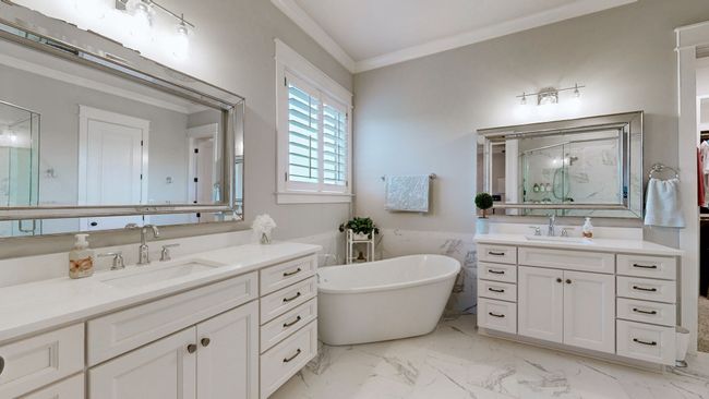 Step into spa-like luxury in this master bathroom featuring dual vanities, a freestanding soaking tub, designer mirrors, and a spacious walk-in shower—all wrapped in elegant finishes and timeless style. | Image 30
