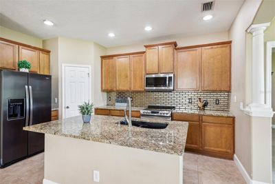 Open kitchen with spacious island, stainless steel appliances and granite counter tops | Image 2