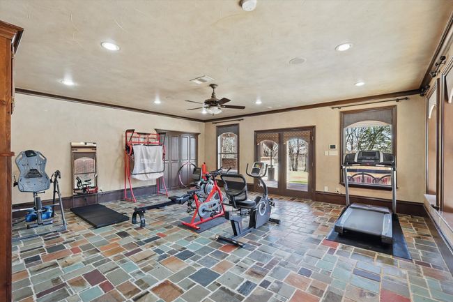 This exercise room has built ins and access to the back patio and pool. This could be a card room, game room, living room etc. | Image 30