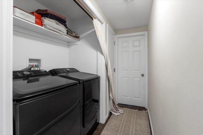 Clothes washing area featuring laundry area, washing machine and dryer, dark wood-type flooring, and baseboards | Image 13