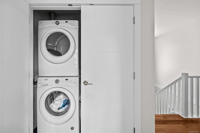 Laundry room featuring stacked washer / dryer and wood finished floors | Image 40