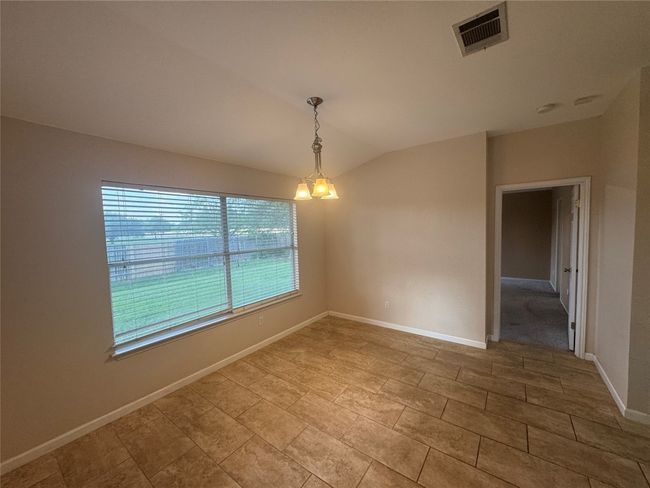Empty room with vaulted ceiling and baseboards | Image 4
