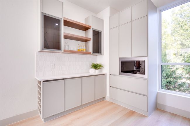Kitchen featuring a wealth of natural light, white cabinetry, and light hardwood / wood-style floors | Image 15